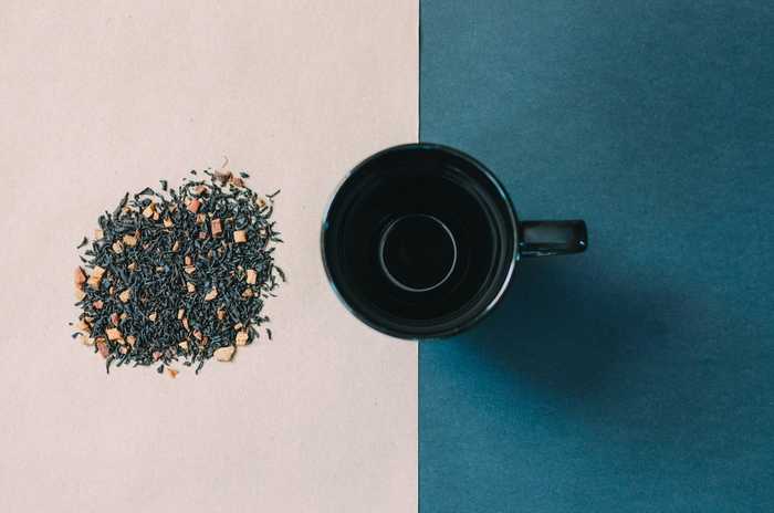 a mug of tea sitting next to a pile of herbs